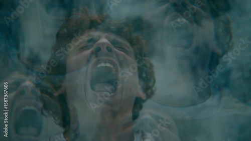 Young man screaming in intense mental anguish, experiencing psychotic episode in asylum ward. Kaleidoscope effect