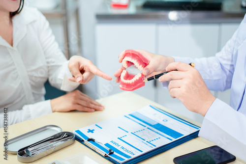 Bilde på lerret An Asian male dentist explains dental health to a middle-aged Asian female patie