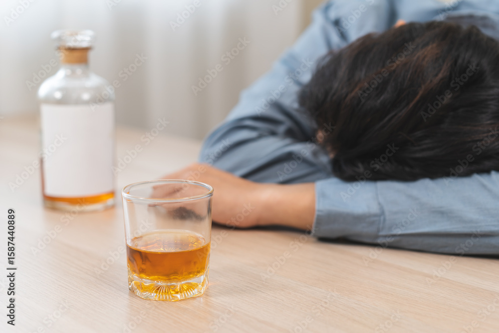 Health care alcoholism drunk, fatigue asian young man holding glass of whiskey, depressed male drink booze, sleep on table at home. Treatment of alcohol addiction, suffer abuse problem alcoholism. Health care alcoholism drunk, fatigue asian young man holding glass of whiskey, depressed male drink booze, sleep on table at home. Treatment of alcohol addiction, suffer abuse problem alcoholism.