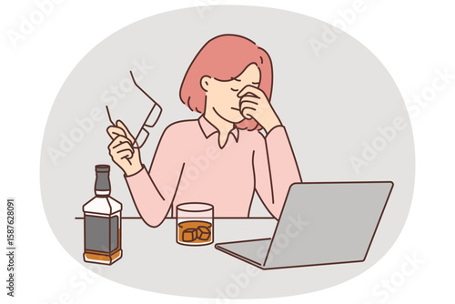 Businesswoman drinks whiskey sitting near laptop and feeling stressed after company goes bankrupt