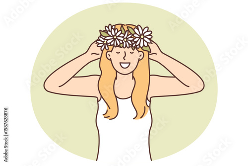 Woman puts on head wreath of spring flowers collected in meadow and rejoices at onset warm weather