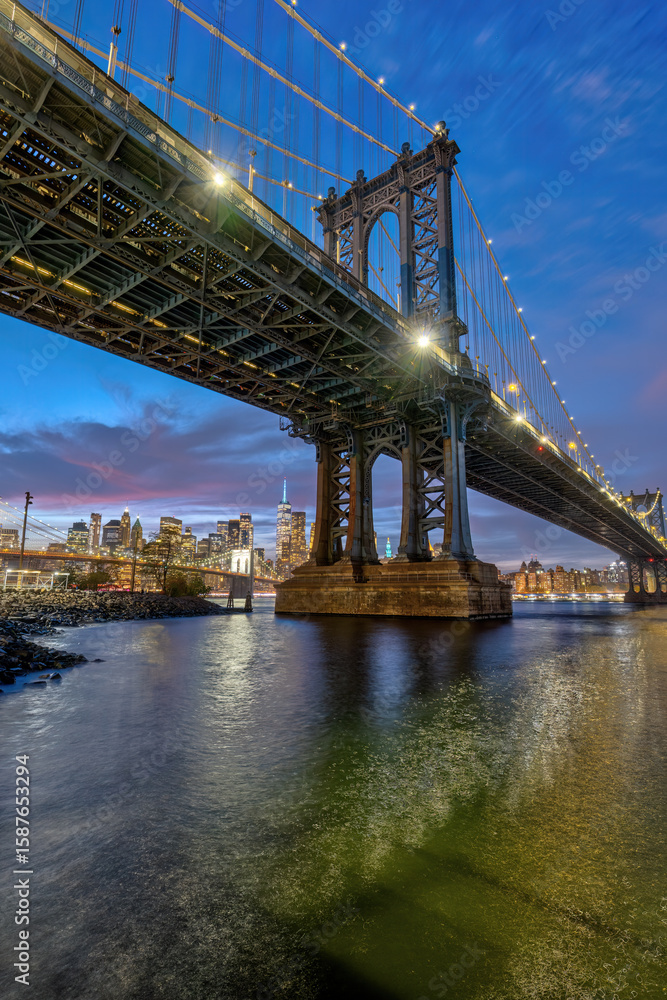Obraz premium The Manhattan Bridge in New York at night with the Brooklyn Bridge and Manhattan in the back
