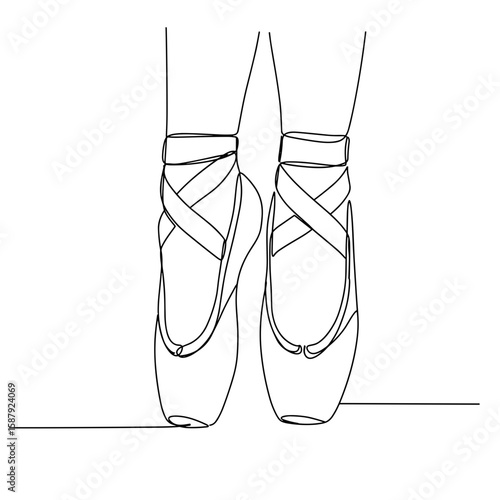 Ballerina feet in pointe shoes with crossed ribbons on floor  