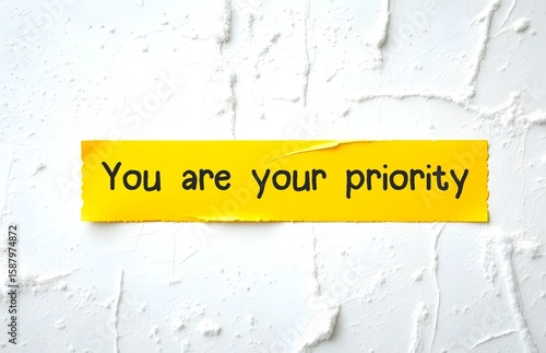 Yellow tale on white wall with handwritten text YOU ARE YOUR PRIORITY, concept of stop being people-pleaser and ignore your own needs - Find a deep belief that you matter. Put yourself first –