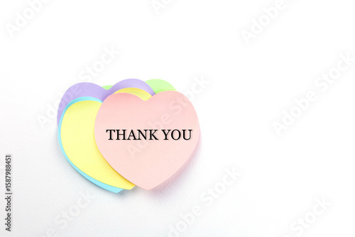 A soft pink heart-shaped sticky note with the word 