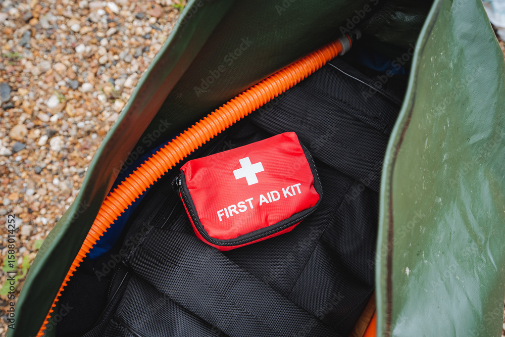 Naklejka premium A first aid kit is sitting inside of a green bag