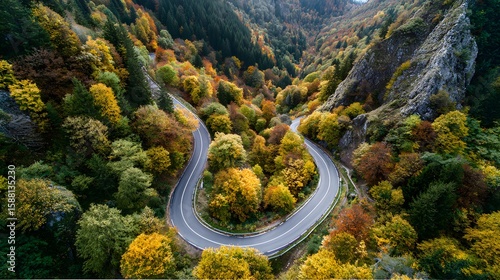 Aerial view of winding mountain road through autumn forest