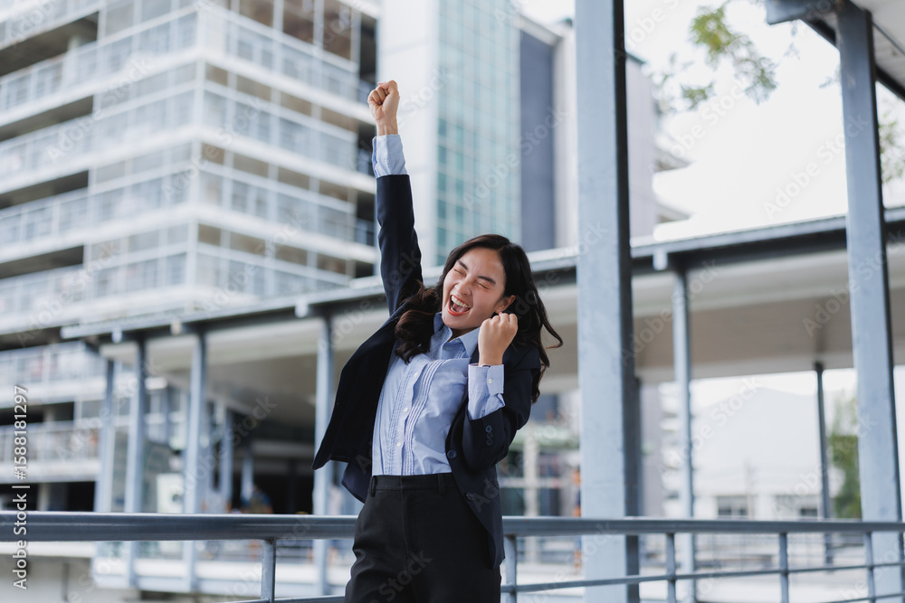 Excited businesswoman celebrating triumph with raised arms in city Excited businesswoman celebrating triumph with raised arms in city