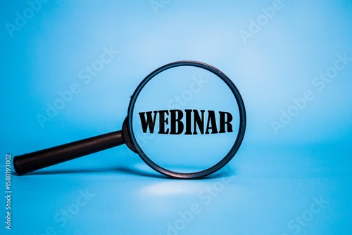 The word WEBINAR on magnifying glasses. The concept of writing on magnifying glasses.