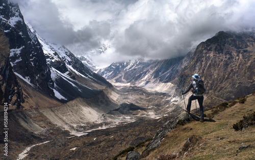 Hiker with backpack against picturesque mountain valley during Manaslu Circui...