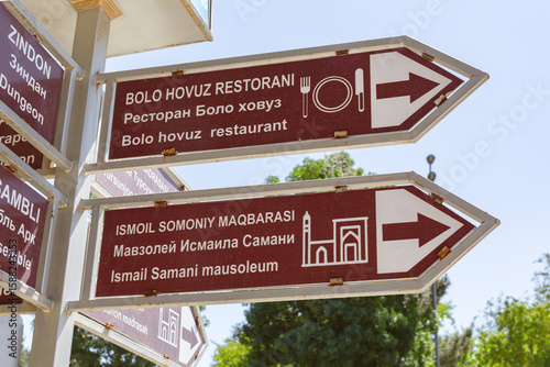 Tourist signpost showing directions to Bolo Hovuz restaurant and Ismail Samani mausoleum in Bukhara, Uzbekistan