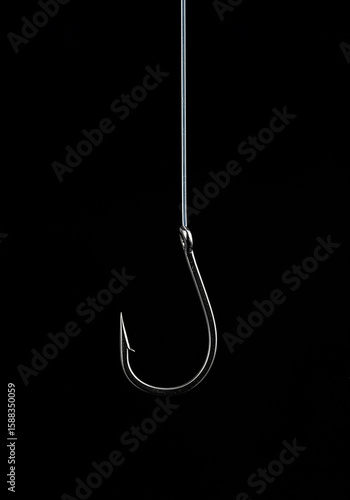 Fishing hook hanging on a line against a black background.