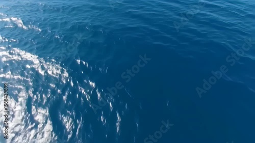 Calm Ocean Surface with Gentle Waves and Sparkling Sunlight Reflection in Aerial Shot