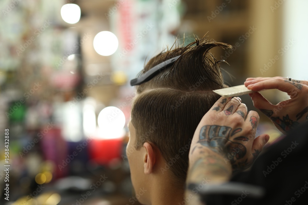 Fototapeta premium Professional barber working with client in barbershop, closeup. Space for text