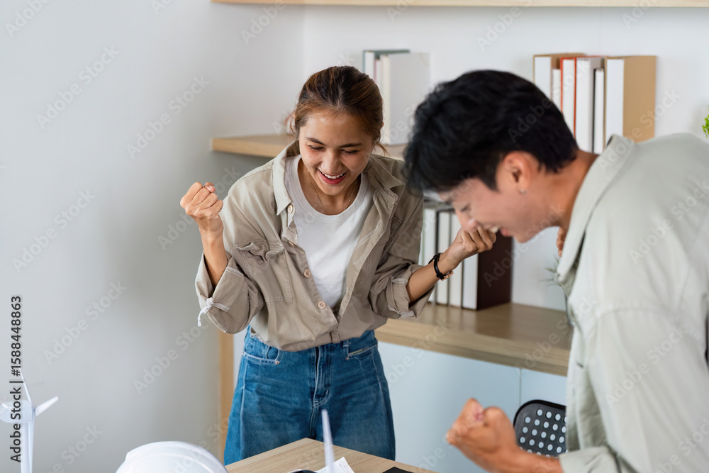 Fototapeta premium Celebrating Success. Young architects expressing joy after a successful project discussion.