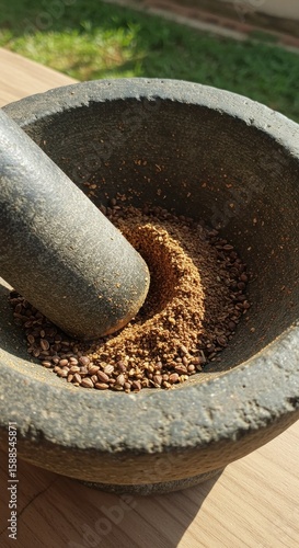 Stone mortar and pestle grinding spice
