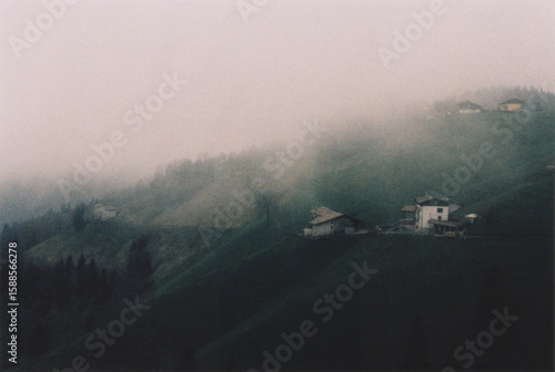 Italian Mountain Village View in the Fog. Beautiful Atmospheric Landscape in the Italian Alps, Bergamo Province. Film Photography
