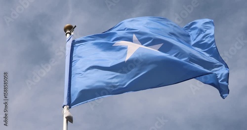The Somali flag is captured in close-up. The Somali flag fluttering against the blue sky is the national symbol of Somalia. Great for news. The video is presented in 4K format.