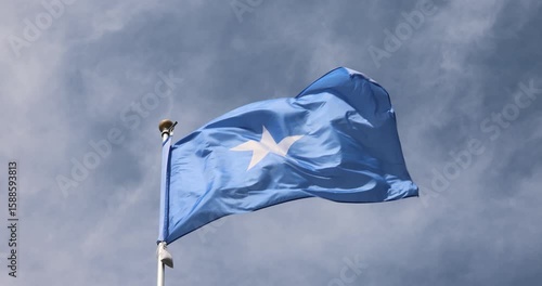 The Somali flag is captured in close-up. The Somali flag fluttering against the blue sky is the national symbol of Somalia. Great for news. The video is presented in 4K format.