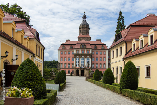 Foto View of a historic pink castle with symmetrical garden path