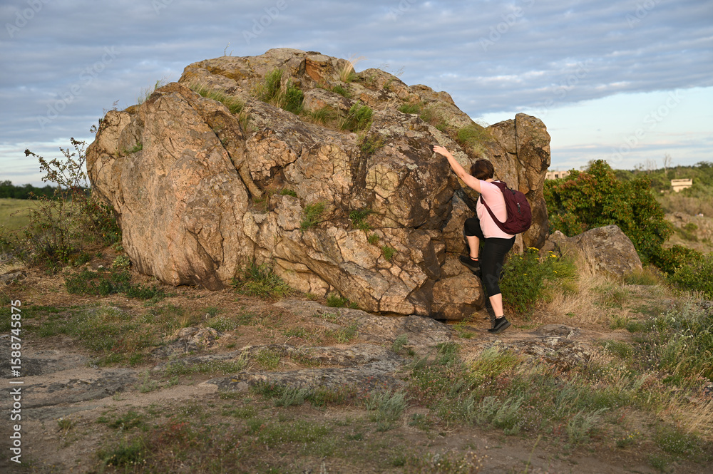 Fototapeta premium female tourist walking with backpack on beach and rocks