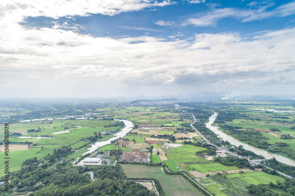 Obraz premium Top view of the Sakae Krang River, Uthai Thani Province where both sides of river are filled with lush green trees. There are community near waterside.