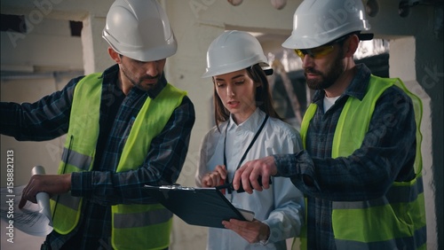 Tableau sur toile Caucasian builders woman men discussing building in construction contractors col