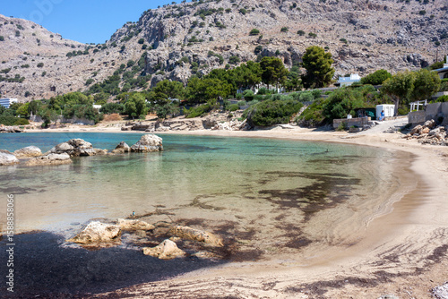Crystal-clear waters of Pefki beach, Rhodes, Greece, meet a pink sandy shore.