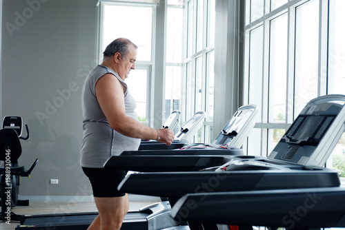 Billede på lærred A man using exercise machines at the gym — promoting the concept of exercising for better health