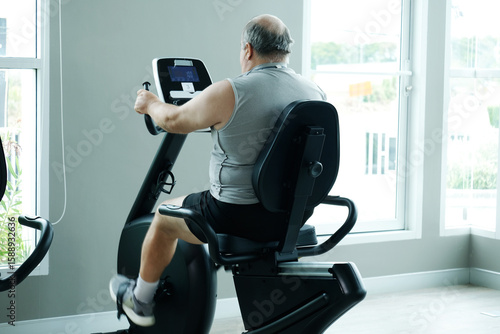 Fotografi A man using exercise machines at the gym — promoting the concept of exercising for better health