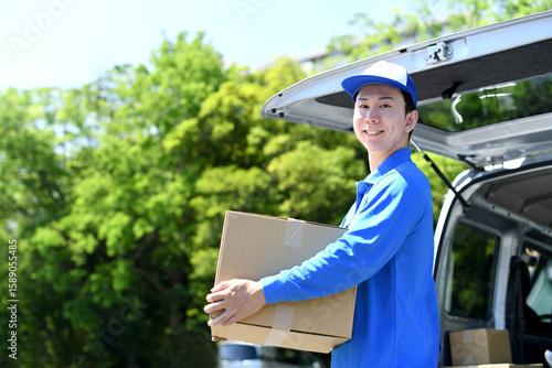 荷物を運ぶアジア人の男性の配達スタッフ