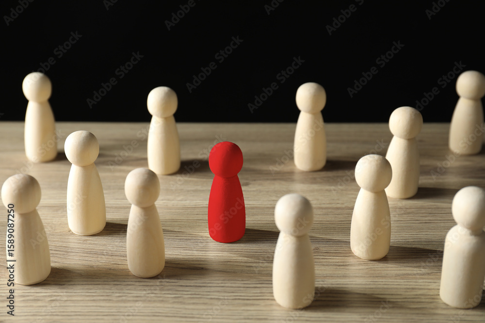 Dismissal. Red figure among wooden ones on table Dismissal. Red figure among wooden ones on table