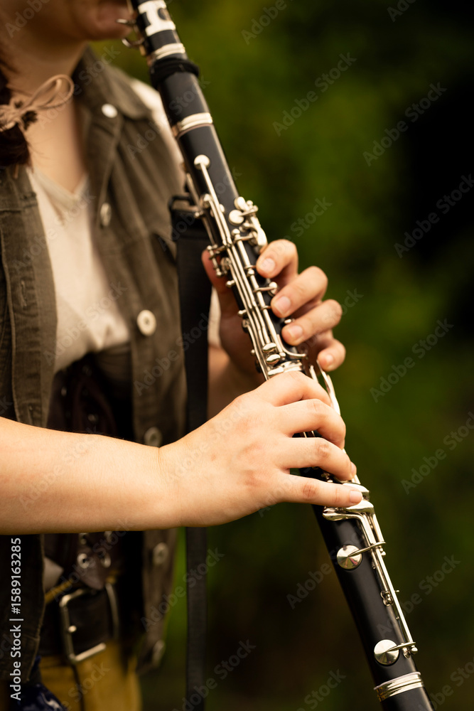 Fototapeta premium Young Musician Playing Clarinet Outdoors in Natural Light