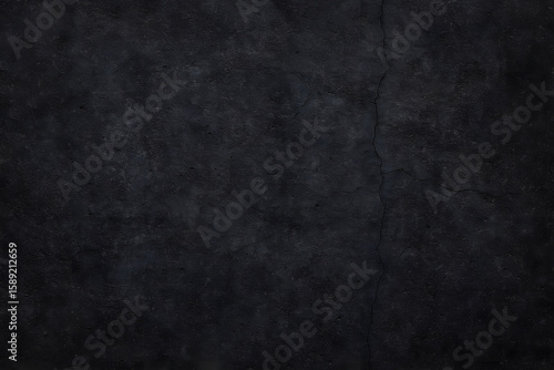 A dark, textured concrete surface displays subtle cracks and imperfections, creating a rugged and moody background