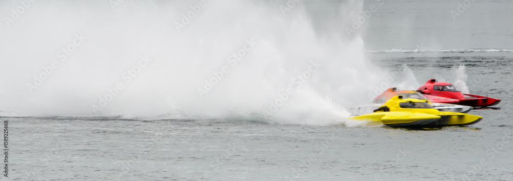 Fototapeta premium Panorama motion blur of three racing speedboats in formation, leaving high spray patterns behind them