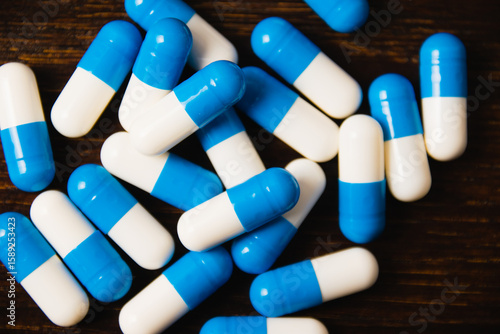 Many pills on a dark background macro. white and blue vitamin pills on a wooden background. Self-medication concept.