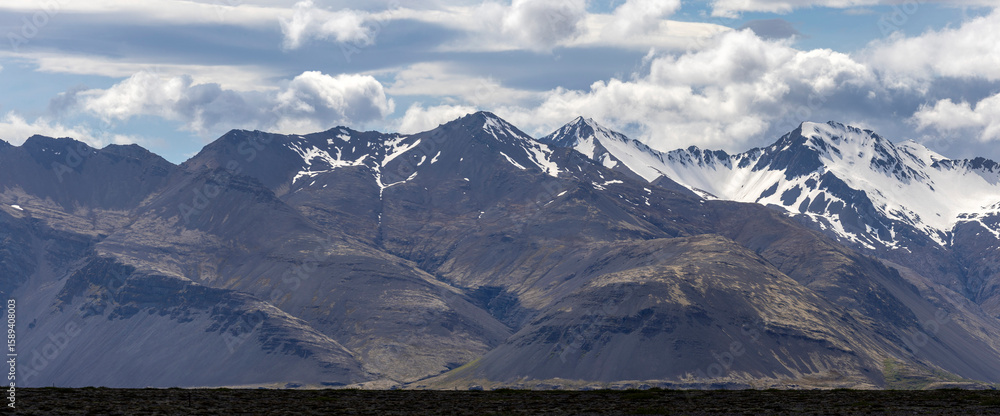Obraz premium snow covered mountains and clouds over the lava field, Southeast Iceland