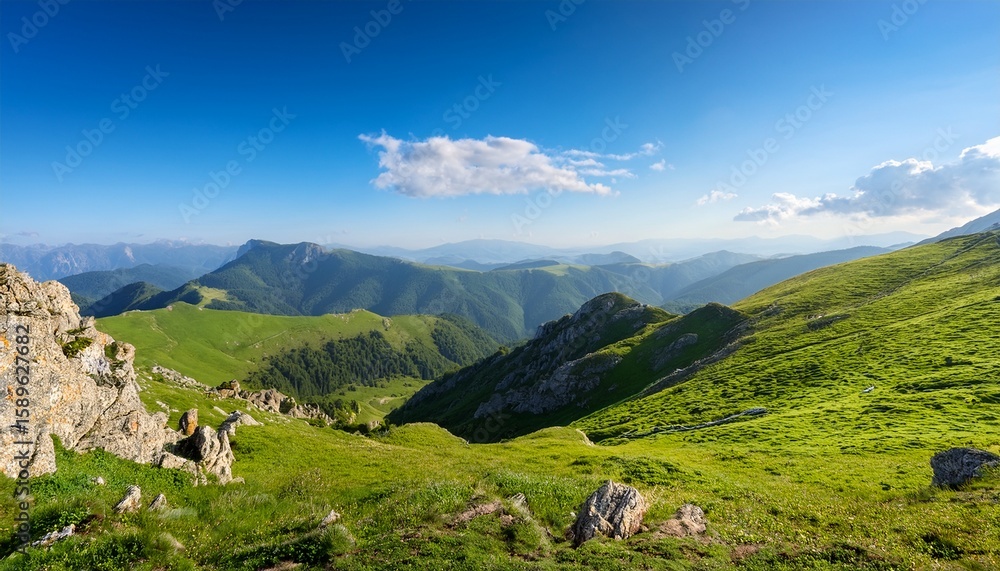 Obraz premium scenic landscape of rolling green hills and rocky cliffs under a bright blue sky in a tranquil mountainous region