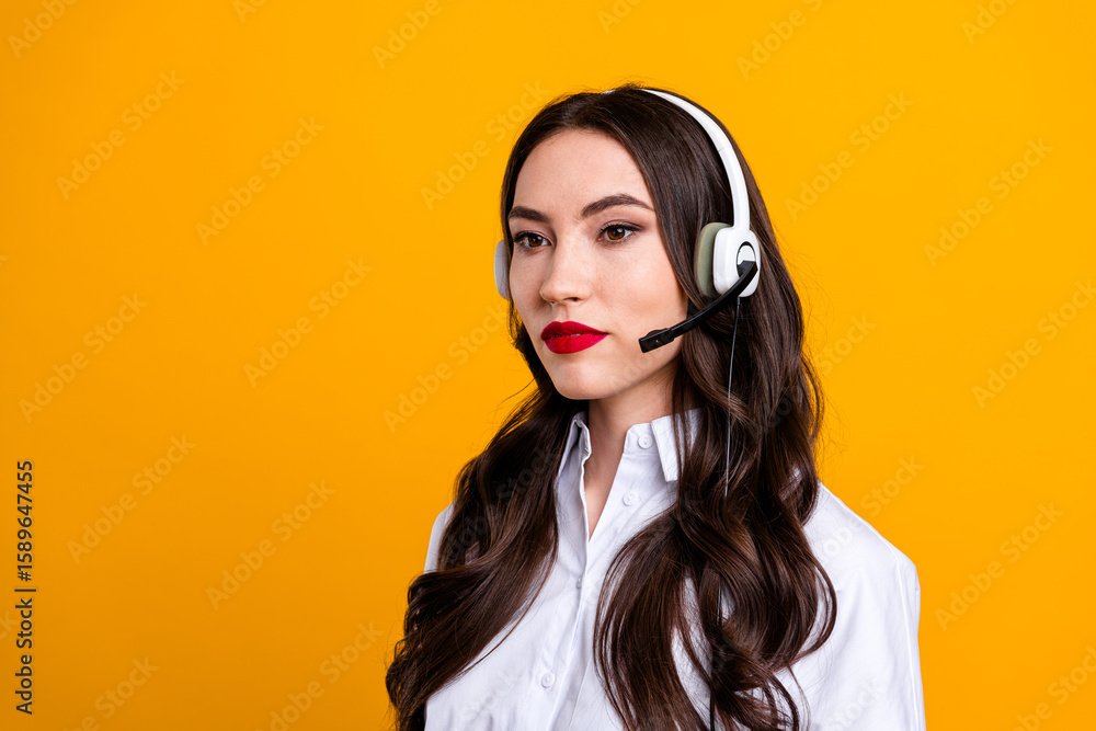 Portrait of a young female professional wearing a headset in formalwear on a yellow background Portrait of a young female professional wearing a headset in formalwear on a yellow background