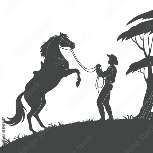 Silhouette of Cowboy Taming Rearing Horse on Hill
