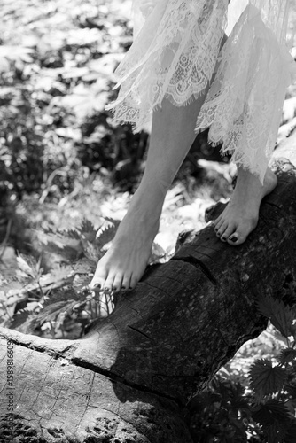 Woman walking barefoot on fallen log