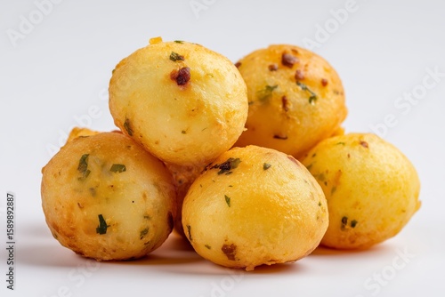 Crispy aloo bonda potato fritters on a clean, white background showcasing their golden color and tempting texture for snack enthusiasts and food lovers