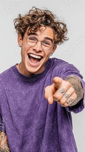 Happy Man With Curly Hair Points and Smiles in a Playful Manner Indoors