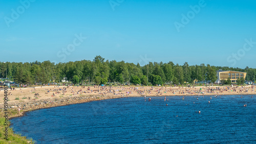 Finland. Sandy beach of Oulu city. Many people relax on a hot summer day on the sea beach.