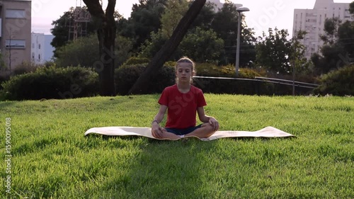 Girl in red tshirt practice yoga on mat,  meditating outdoors during school activity, meditation, exercise, fitness, mindfulness
