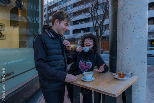 Two people enjoying coffee break outside cafe
