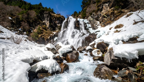 Mountain waterfall cascading through snowy landscape