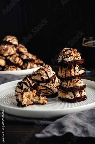 Macaroons Drizzled with Dark Chocolate on a Small Plate: Toasted coconut meringue drop cookies dipped in bittersweet chocolate close-up