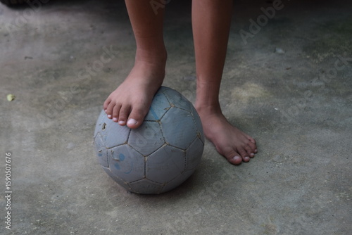 Children play football barefoot