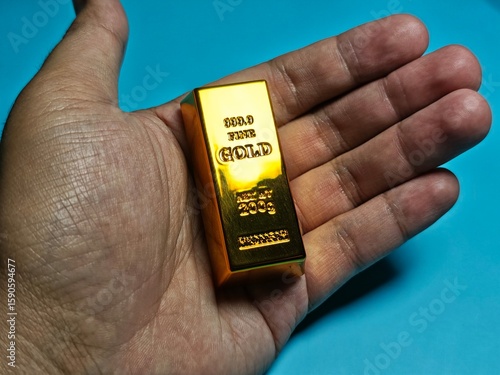 hand holding a gold bar